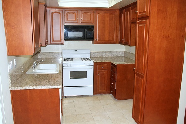 New kitchen with custom cherry wood cabinets, granite counters and Travertine floor 